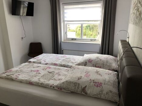 Schlafzimmer im EG mit Boxspringbett und Flat-TV