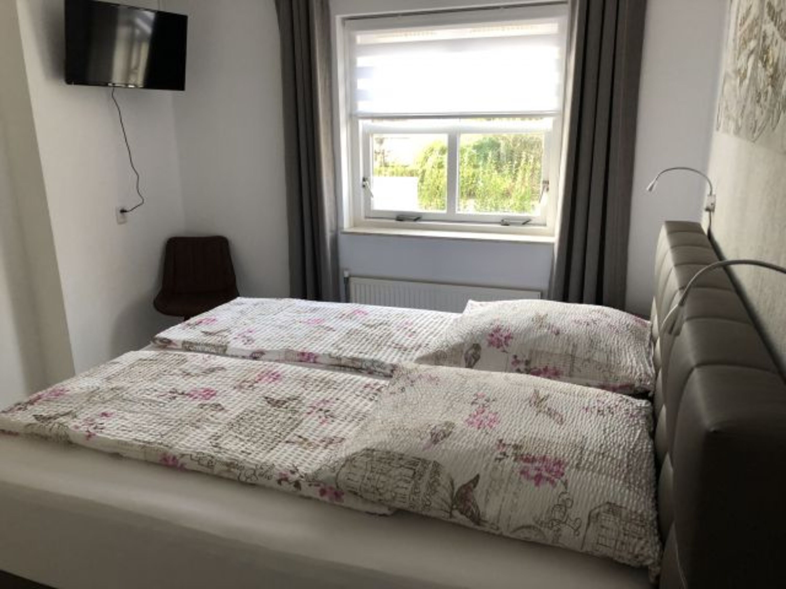 Schlafzimmer im EG mit Boxspringbett und Flat-TV