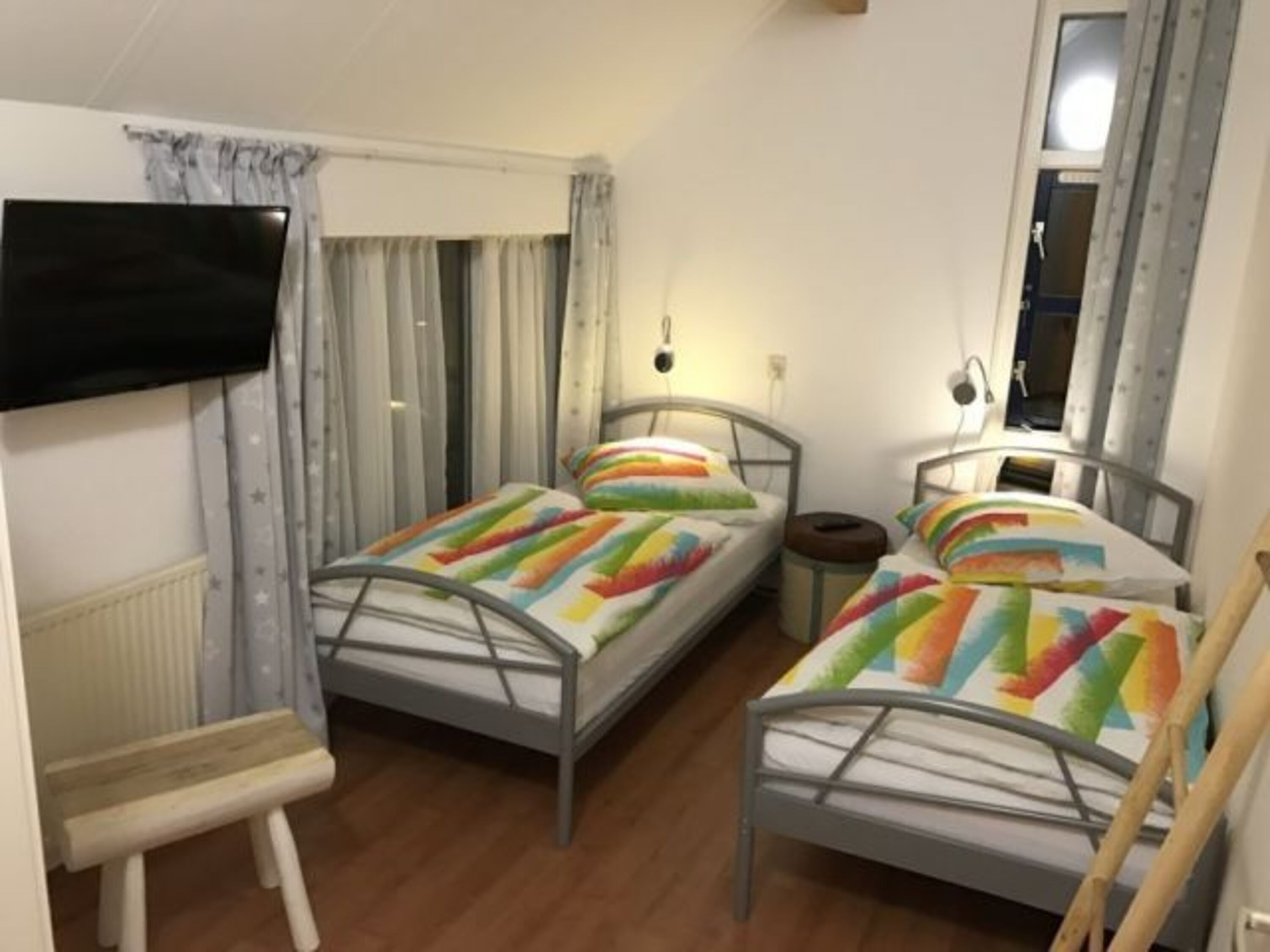 Schlafzimmer im OG mit zwei Einzelbetten, Leselampen und Flat-TV