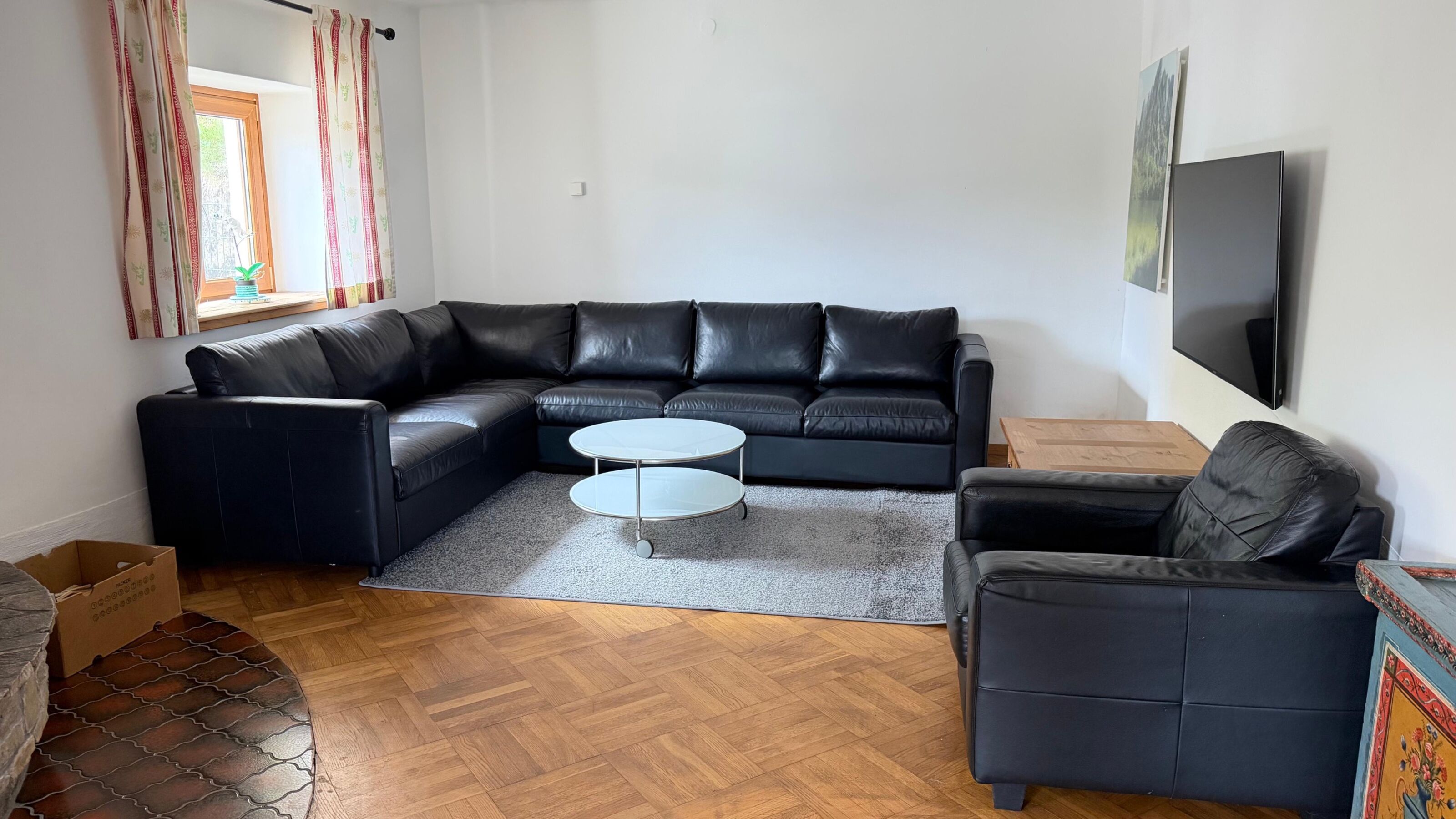 Wohnzimmer im unteren Stockwerk mit Ledercouch und Flat TV.