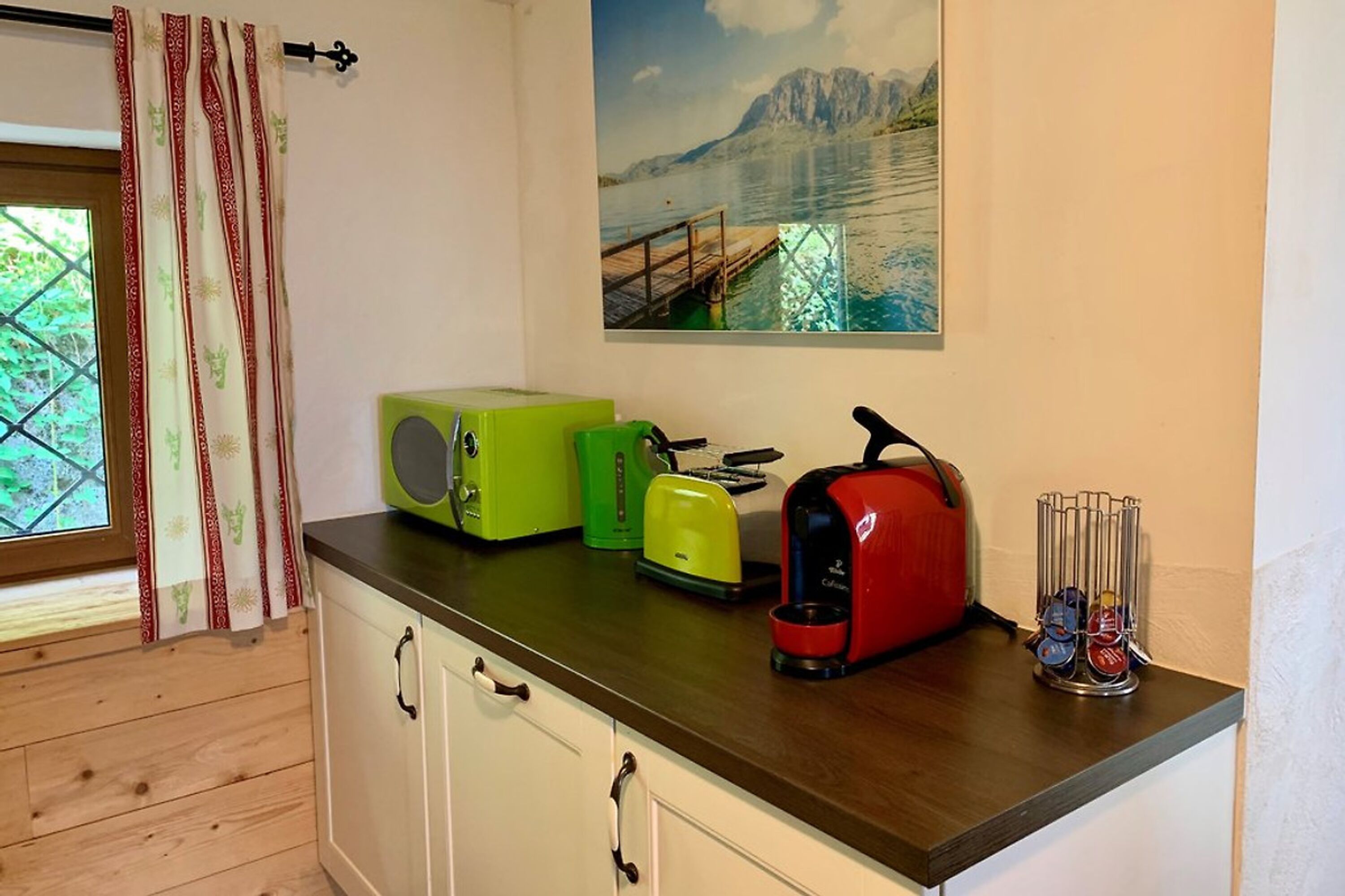 Küche mit Waschmaschine, Wasserkocher, Tschibo Caffissimo und Toaster.
