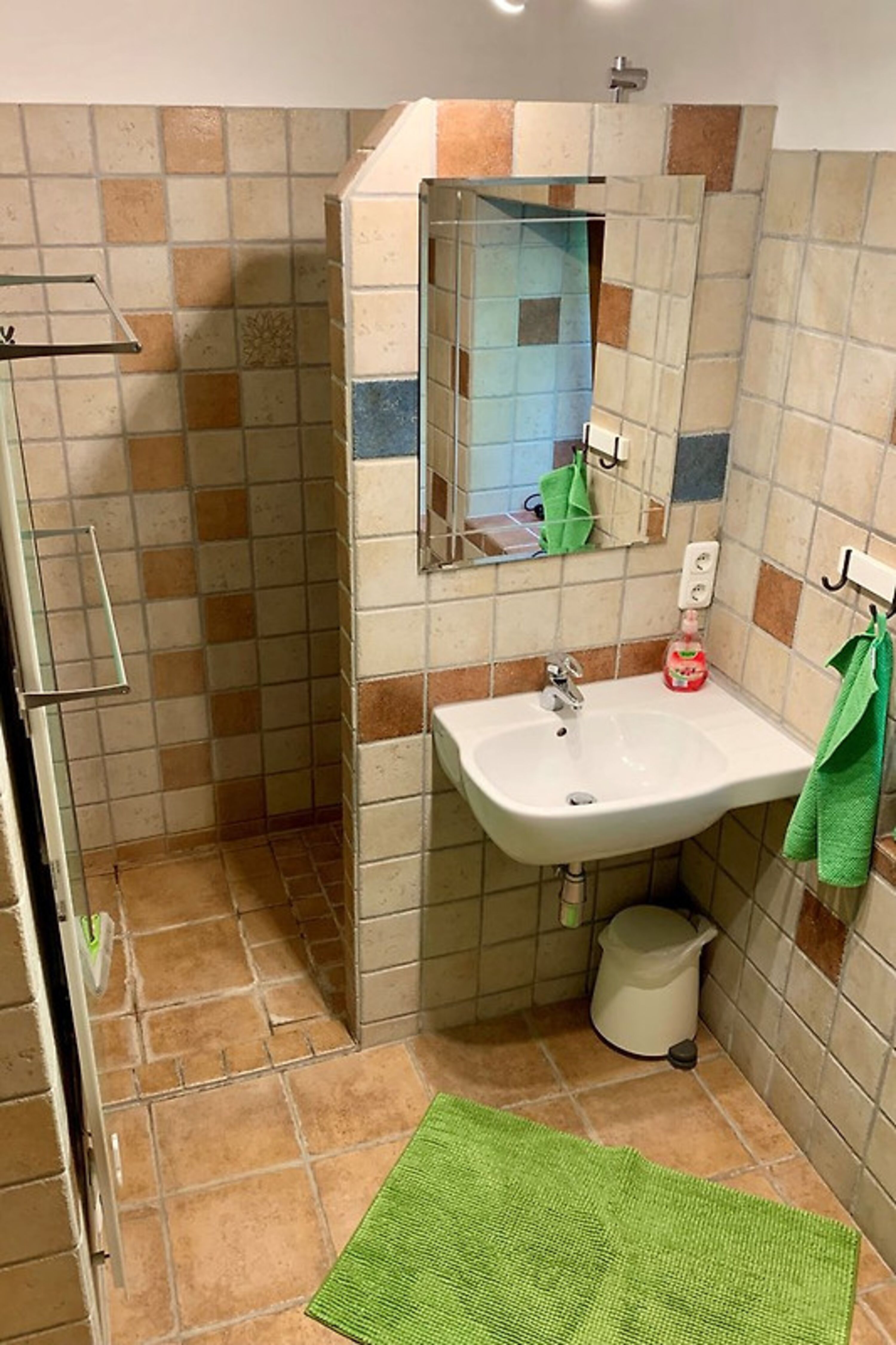 Im Erdgeschoss Badezimmer mit ebenerdiger Dusche, Waschbecken, Fenster und Badewanne.