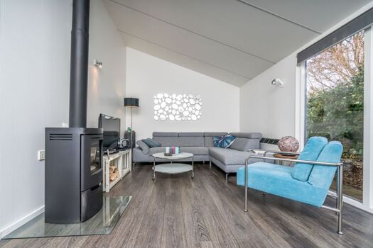 Das helle, gemütliche Wohnzimmer mit Kaminofen