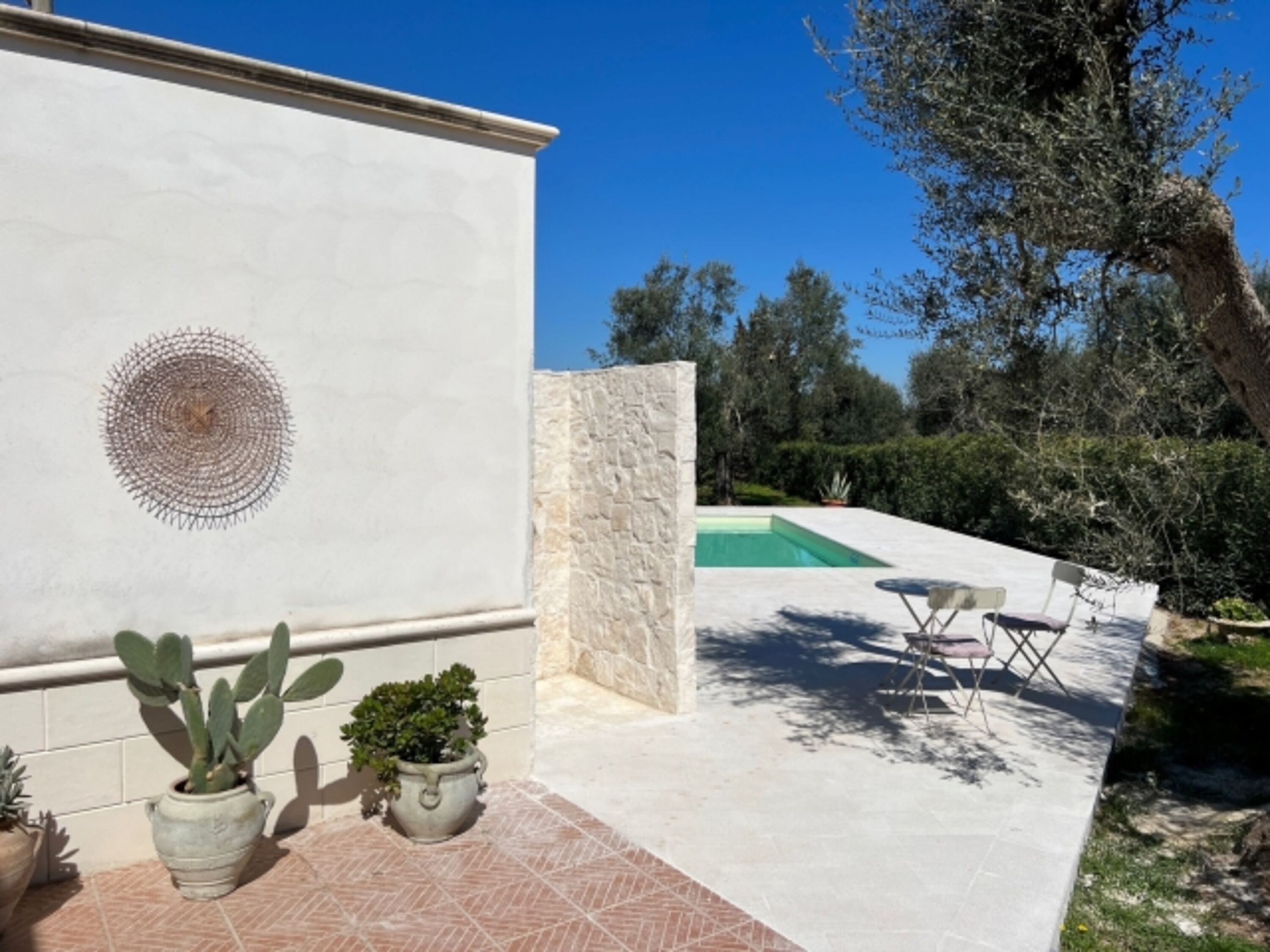 Blick vom Haus zu Pool und gemauerter Dusche