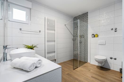 Schlafzimmer Nr. 1 mit einem Queensize-Bett (160 cm x 200 cm), einem Flachbildfernseher und einem eigenen Badezimmer sowie Blick auf den Pool