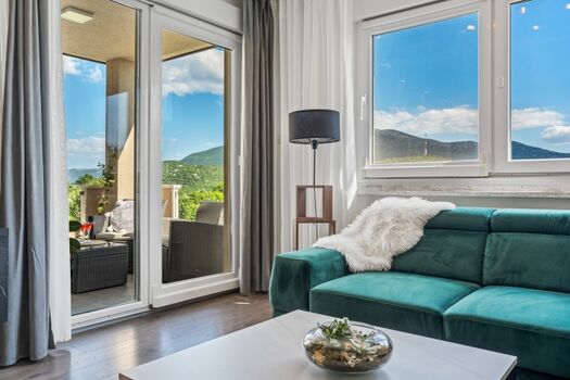 Der Innenraum der Villa BEYBE bietet einen klimatisierten Wohn- und Essbereich mit TV und einen Ausgang zur Lounge-Ecke im Freien mit Blick auf den Poolbereich