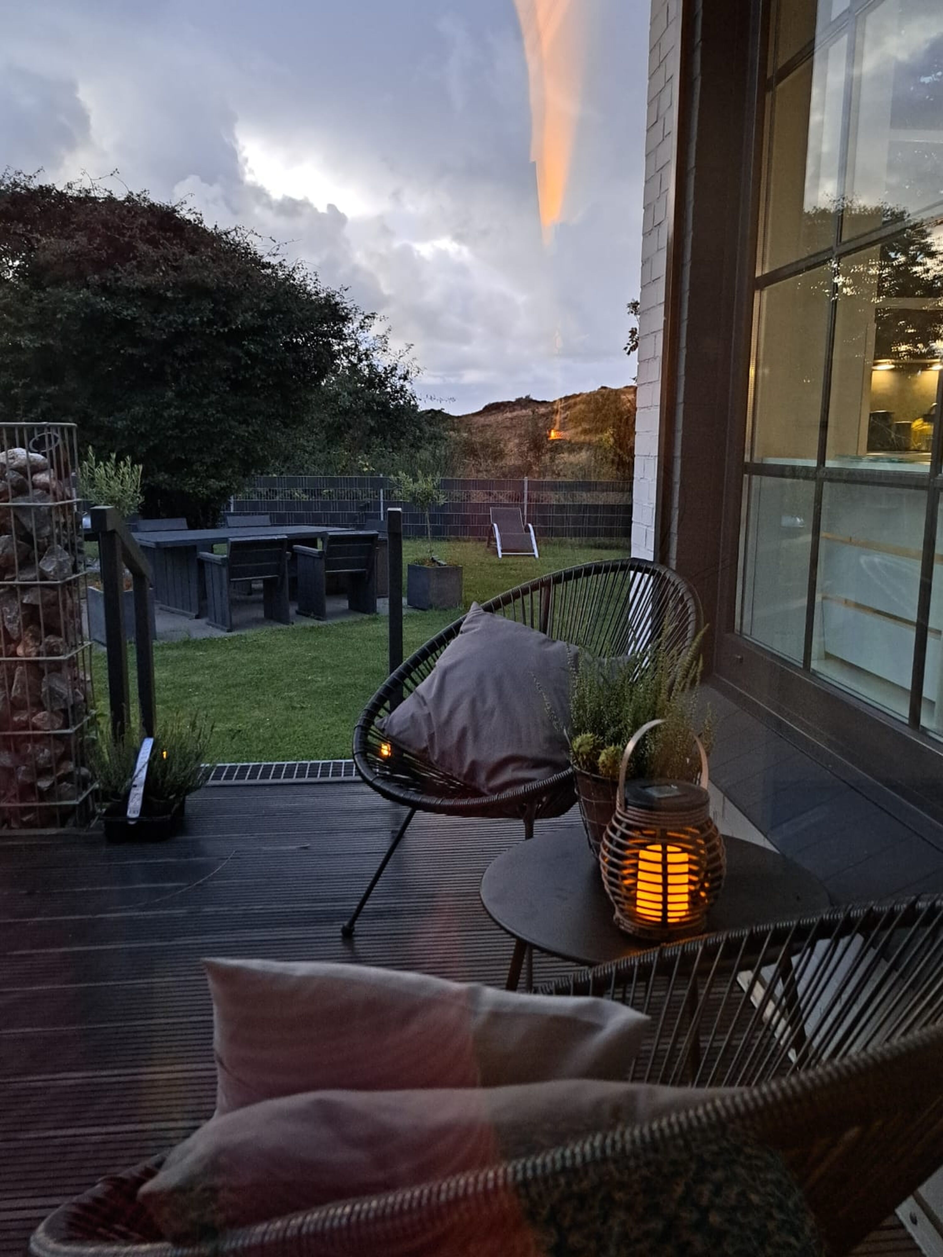 Eingezäunter Garten mit Loungemöbeln Strandkorb und Grill