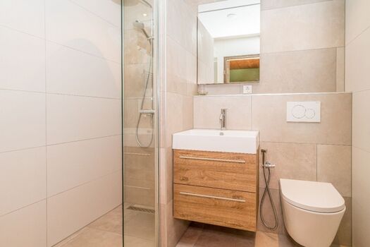 neues Badezimmer mit Dusche, Waschbecken und Toilette.