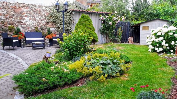 Hoch eingezäunter Garten mit Terrasse und Grill 