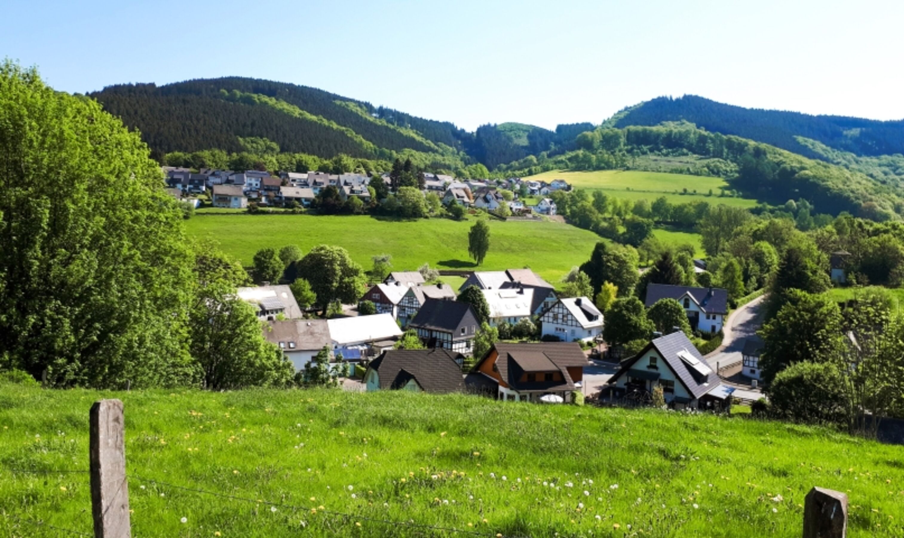 Blick auf die Häuser am Wald von der gegenüberliegenden Talseite