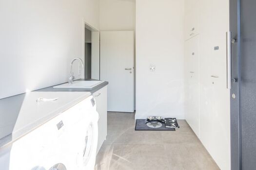 Georgs Huis - Helle Waschküche mit Waschmaschine, Trockner und Waschbecken 