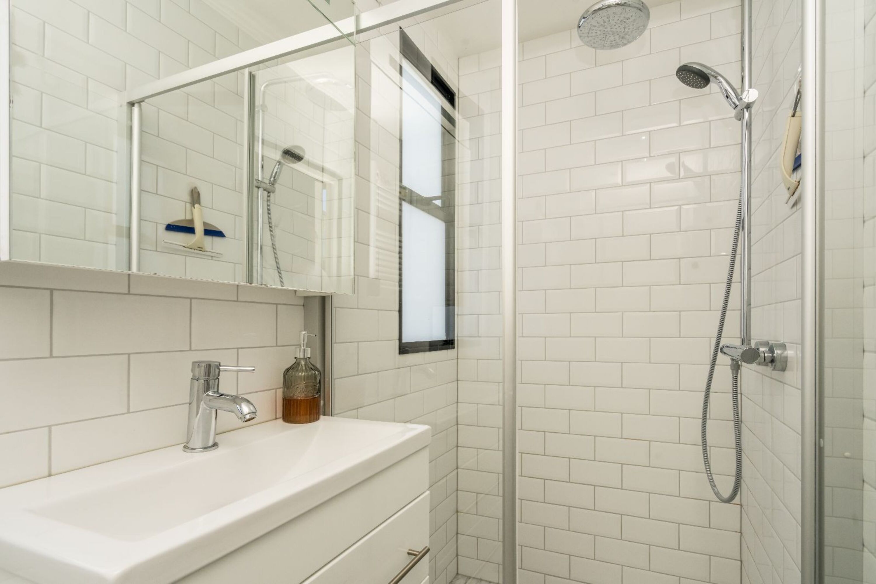 Badezimmer mit Regendusche, Waschbecken und Toilette